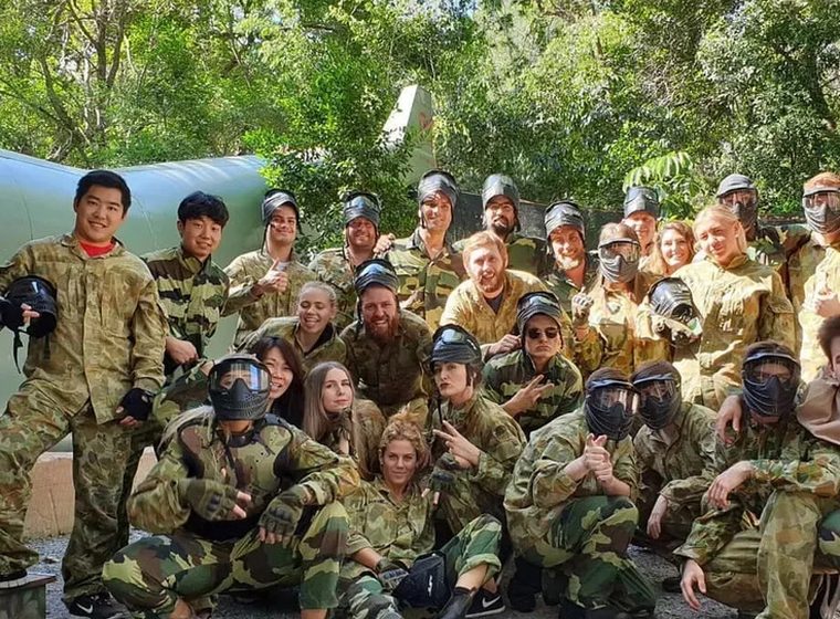 A paintball group in camo and full face protection