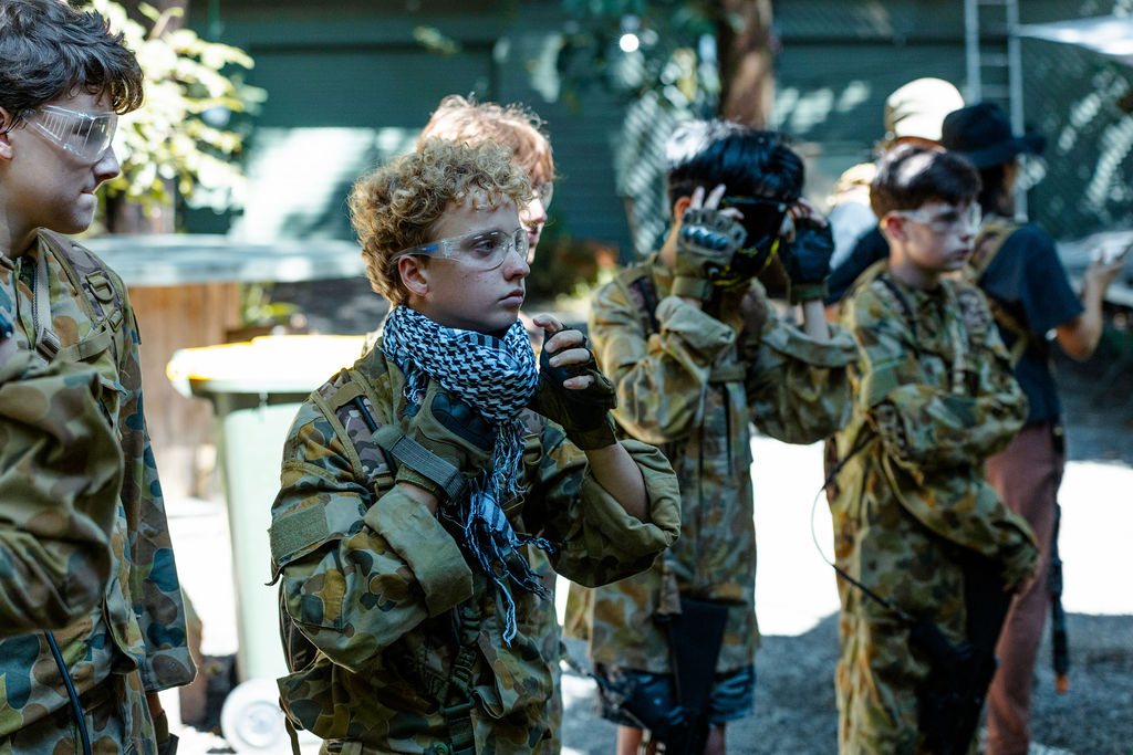 Kids in camo gear and team colours during a birthday party session at Twin Waters