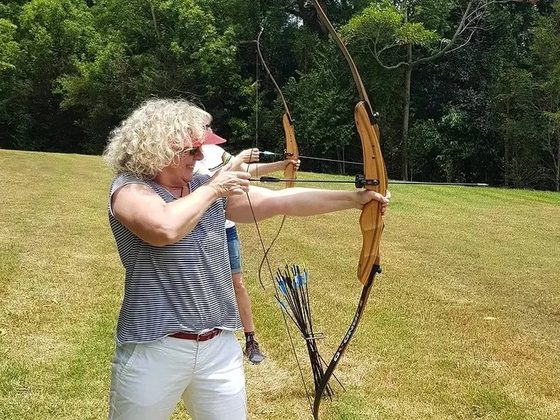 An archer at full draw on the outdoor range