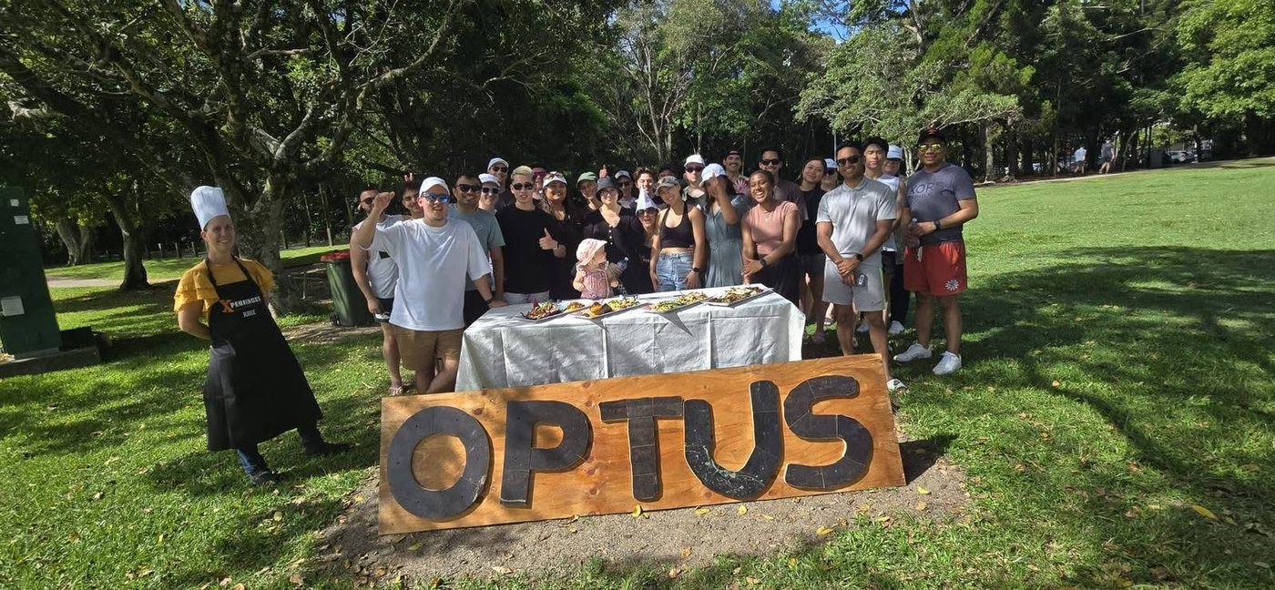 A corporate group at an Xperiences team-building day, Optus branding on the field